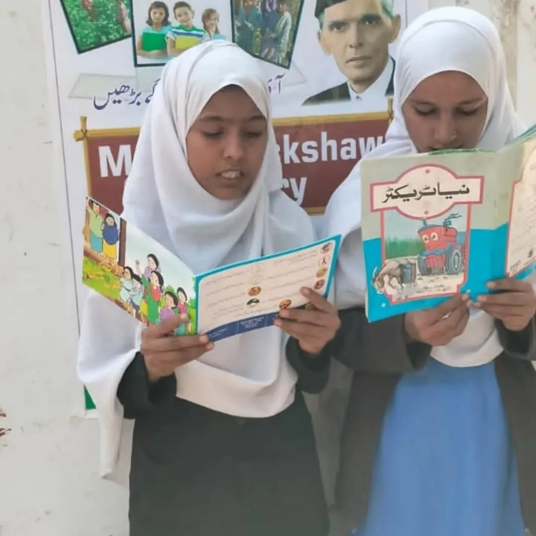 Girls reading books from the Mobile Rickshaw Library